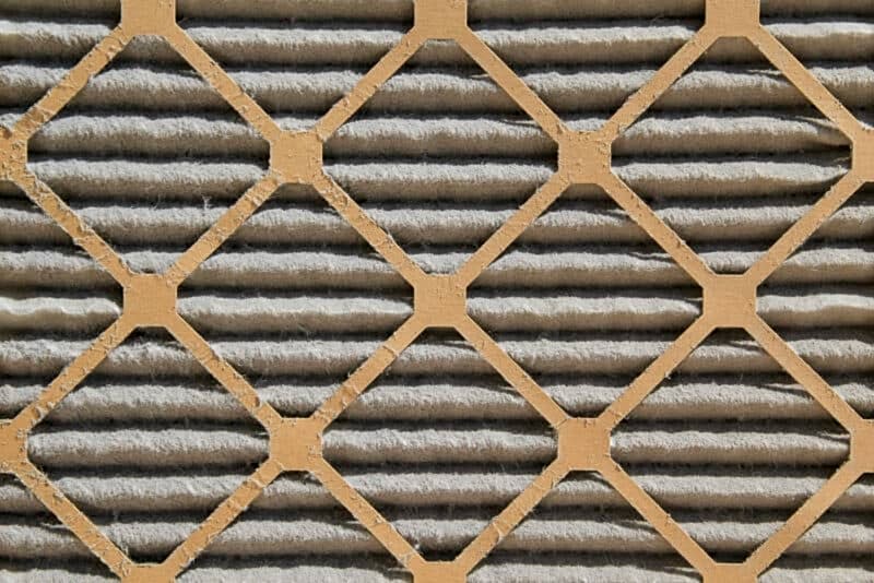 closeup of a dirty air filter covered in dust